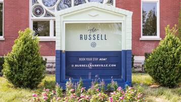 Een bord voor Hotel The Russell met een melding om te reserveren en een website-URL.