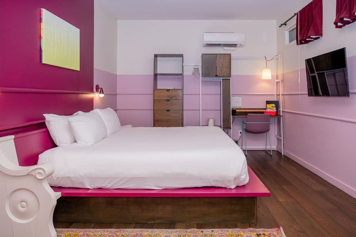 Ein Schlafzimmer mit Bett, Schrank, Schreibtisch und Stuhl.