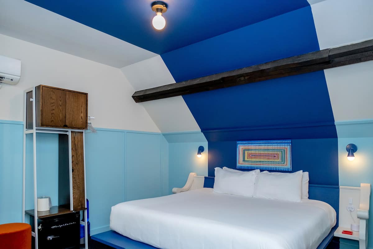 Ein Schlafzimmer mit einem Bett, einem Holzschrank, einem Schreibtisch und einem Stuhl.
