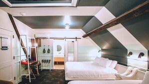 Un dormitorio moderno y funcional con tragaluz, un escritorio pequeño y un vestidor.