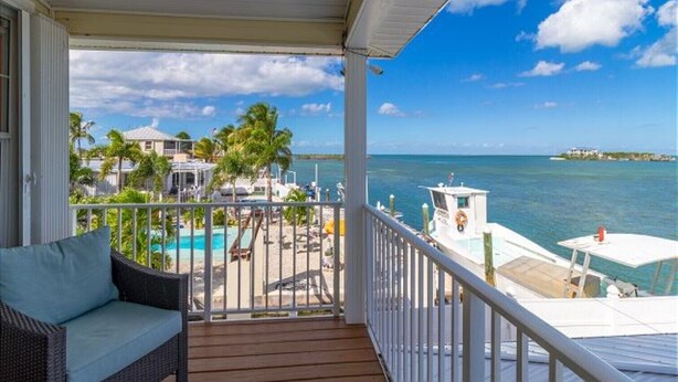 A balcony with a view of the ocean, a pool, and a small island in the distance. - Copacabana, Overlooking the Gulf! (Marathon)