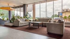 A spacious lobby with large windows, a modern sofa set, and a coffee table.