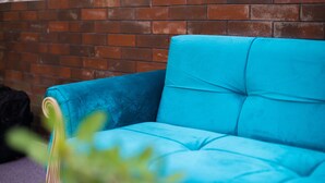 Un sofà blau davant d'una paret de rajola.