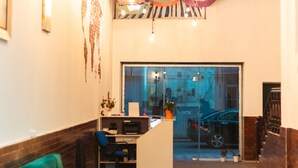 Un hall amb un sofà verd, una taula petita i una decoració de sostre colorida.
