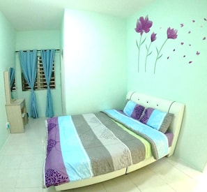 Una camera da letto con un letto, tende, una cassettiera e una decorazione a parete.