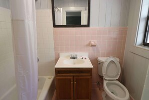 A bathroom with a bathtub, a sink, and a toilet. - Travelodge By Wyndham Gatlinburg (Gatlinburg)