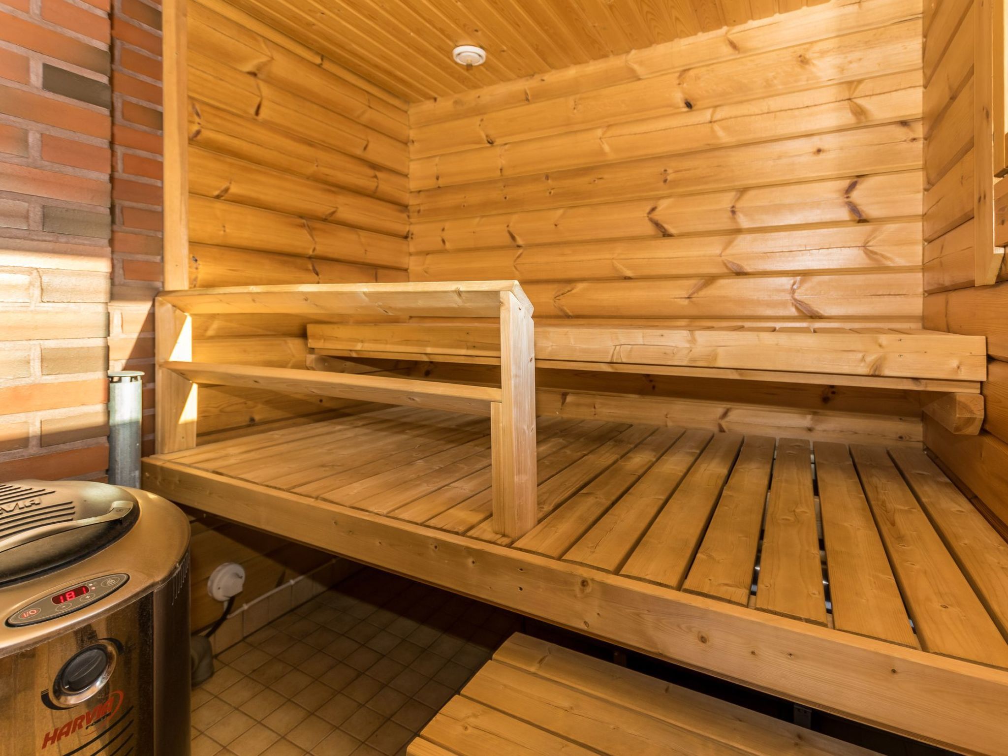 Un sauna avec des bancs en bois et un panneau de commande.