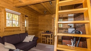 A log cabin interior with a sofa, dining table, and a kitchen area. - Joutsen by Interhome (Jämsä)