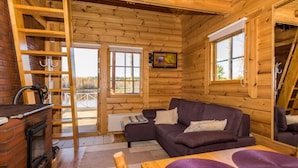 A cozy cabin interior with a wooden interior, a fireplace, a sofa, and a dining table. - Joutsen by Interhome (Jämsä)