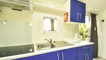 Een koelkast, kookgerei, borden en bestek