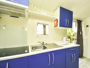 Een koelkast, kookgerei, borden en bestek