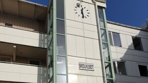 A building with a clock on the facade, a sign reading "SKOLHUSET," and a sign for "RÄDDNINGSSKOLAN SKÖVDE." - Räddningsskolans lägenhetshotell (Skovde)