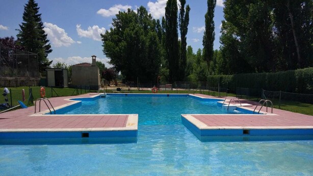 A rectangular swimming pool with two diving platforms, surrounded by a fence and trees. - Precious century-old house recently restored, original stone and wooden beams (Segovia)