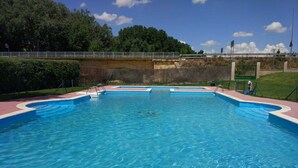 A rectangular swimming pool with a blue interior and a surrounding walkway. - Precious century-old house recently restored, original stone and wooden beams (Segovia)