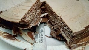 A cake with a visible layer of chocolate and cream, placed on a white plate. - Precious century-old house recently restored, original stone and wooden beams (Segovia)