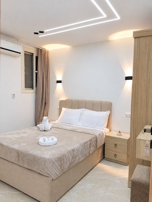 Um quarto moderno com cama, mesas de cabeceira e um criado-mudo.