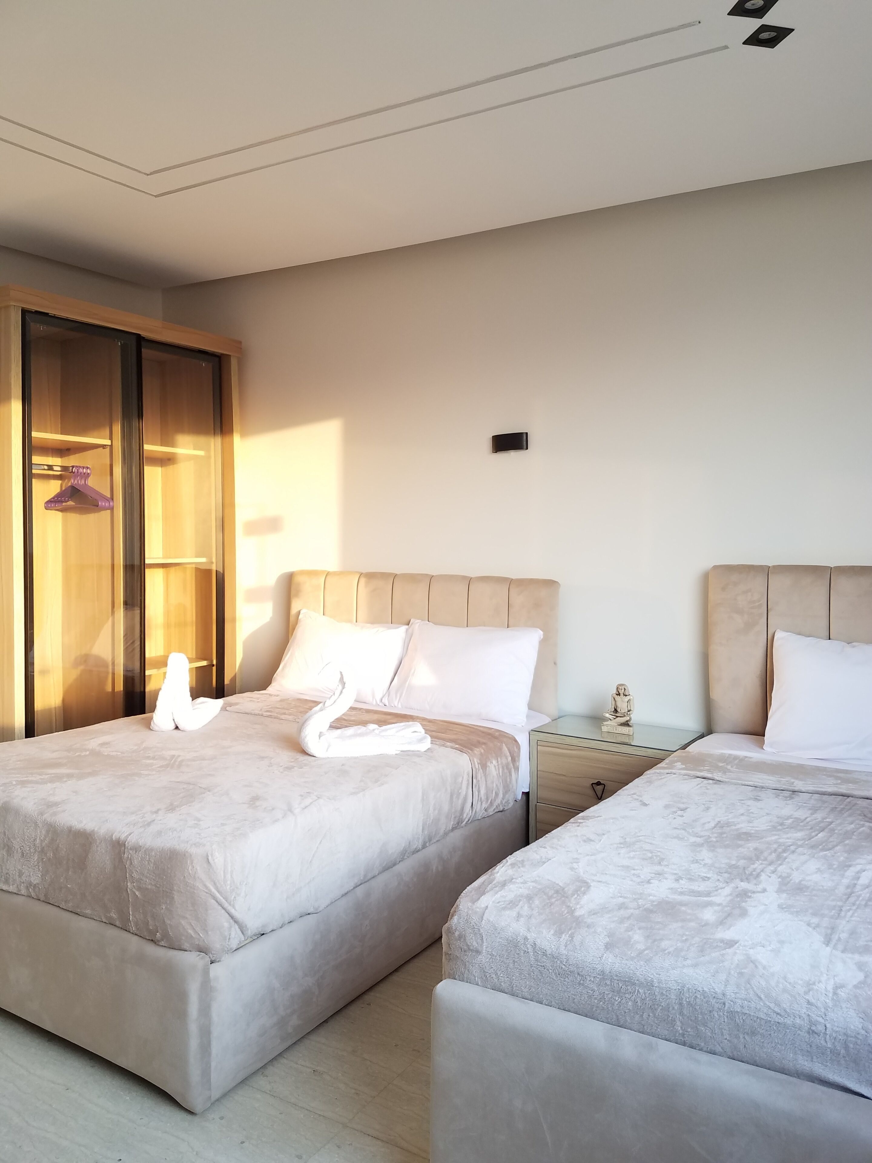 Una habitación de hotel con dos camas, un armario y una mesita de noche.
