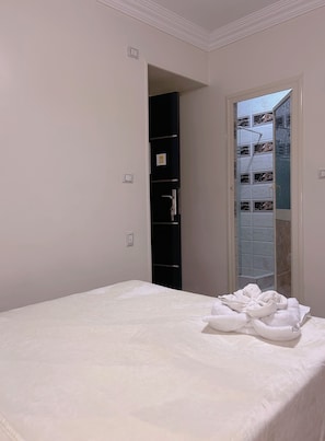 A bedroom with a bed, a wardrobe, and a bathroom visible through an open door. - Pyramids Terrace INN (Giza)