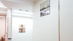 Un pasillo con una escalera, una recepción y un cuadro en la pared.