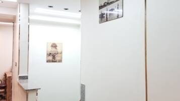 A hallway with a staircase, a reception desk, and a wall-mounted picture.
