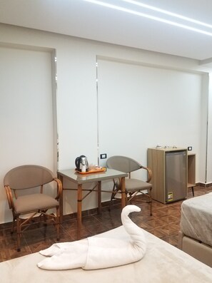 A room with a dining table, two chairs, a refrigerator, and a bed. - Pyramids Terrace INN (Giza)