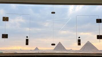 Una ventana con vista a las pirámides y un cielo despejado.