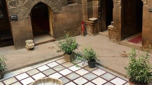 An indoor courtyard with a fountain, potted plants, and stone walls. - Pyramids Terrace INN (Giza)
