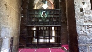 An arched stone corridor with hanging light fixtures and a central gate. - Pyramids Terrace INN (Giza)