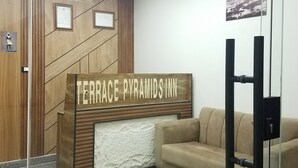 A reception desk with a sign reading 'TERRACE PYRAMIDS INN' and a beige sofa in the background. - Pyramids Terrace INN (Giza)