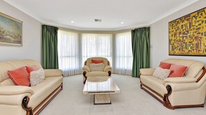 Relax in a classic living room with two sofas, armchairs, and a central coffee table.