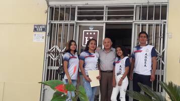 A group of people standing in front of a building with a sign that reads "Hostal Hogar".