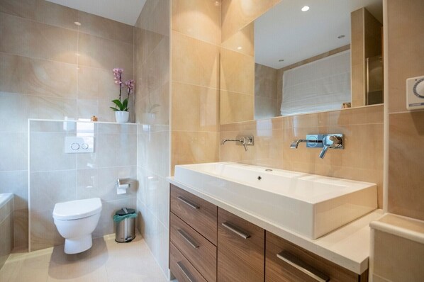 A modern bathroom with a large white sink, a mirror, and a toilet. - Luxury villa Saga in Drvenik, private pool (Drvenik)