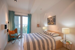 A modern hotel room with a large bed, a chair, a desk, and a view of the outdoors. - Luxury villa Saga in Drvenik, private pool (Drvenik)