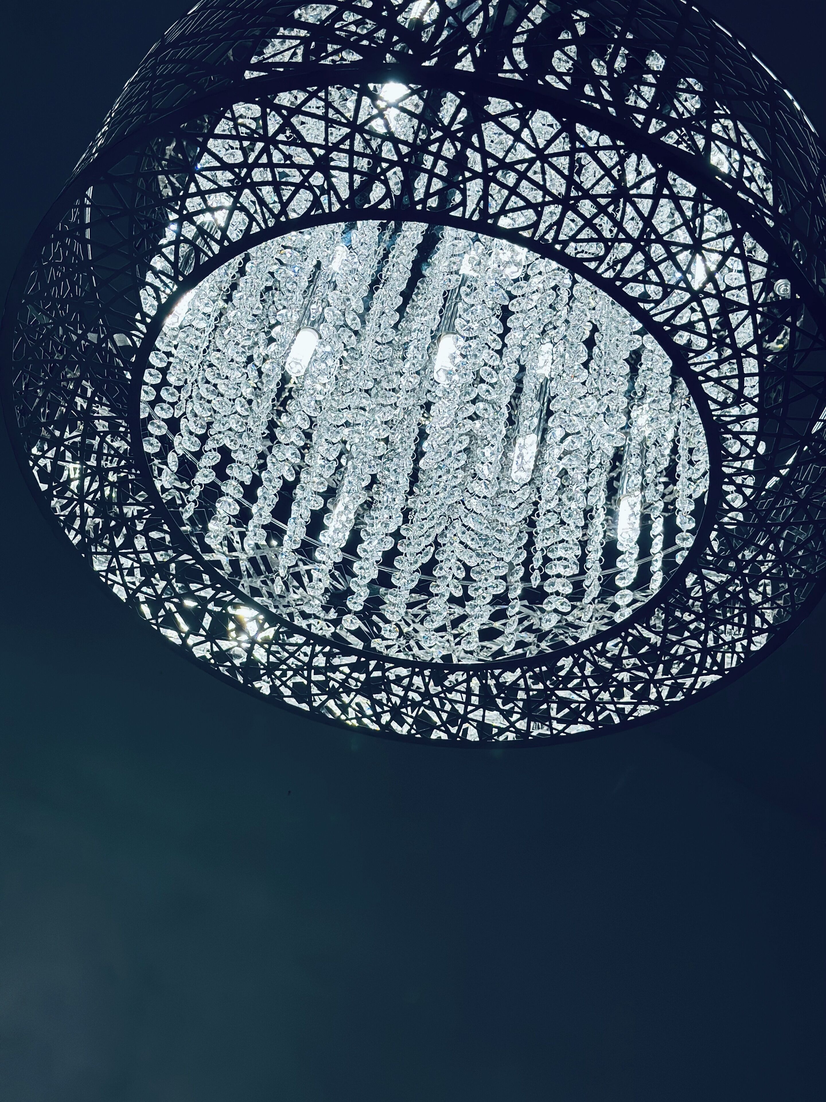 Una estructura esférica con un intrincado entramado geométrico y múltiples superficies reflectantes.