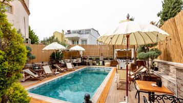 Kolam renang outdoor musiman, dengan kursi berjemur