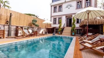 Kolam renang outdoor musiman, dengan kursi berjemur