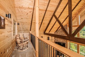 Cozy cabin interior with a high ceiling and rustic fireplace, perfect for relaxation.