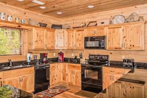 Enjoy cooking in this well-equipped kitchen with a double sink, oven, and microwave.
