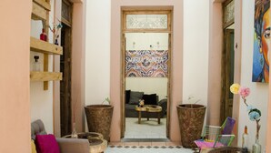 A cozy living area with a sofa, chairs, a coffee table, and a large mirror. - Maria Bonita - Hostel (Guadalajara)