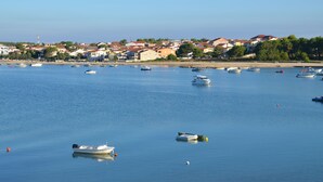Un pueblo costero con barcos en aguas tranquilas, casas a lo largo de la orilla y un cielo despejado.