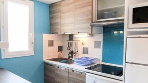 A compact kitchen with a dishwasher, a microwave, and a sink. - Les Roches Bleues by Interhome (Collioure)