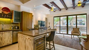 Una cocina moderna con una isla grande, armarios de madera y un comedor con vistas al exterior.