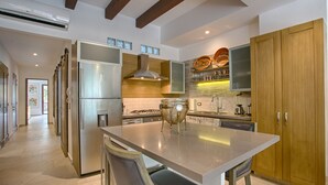 Una cocina moderna con una isla central, electrodomésticos de acero inoxidable, armarios de madera y un horno empotrado.