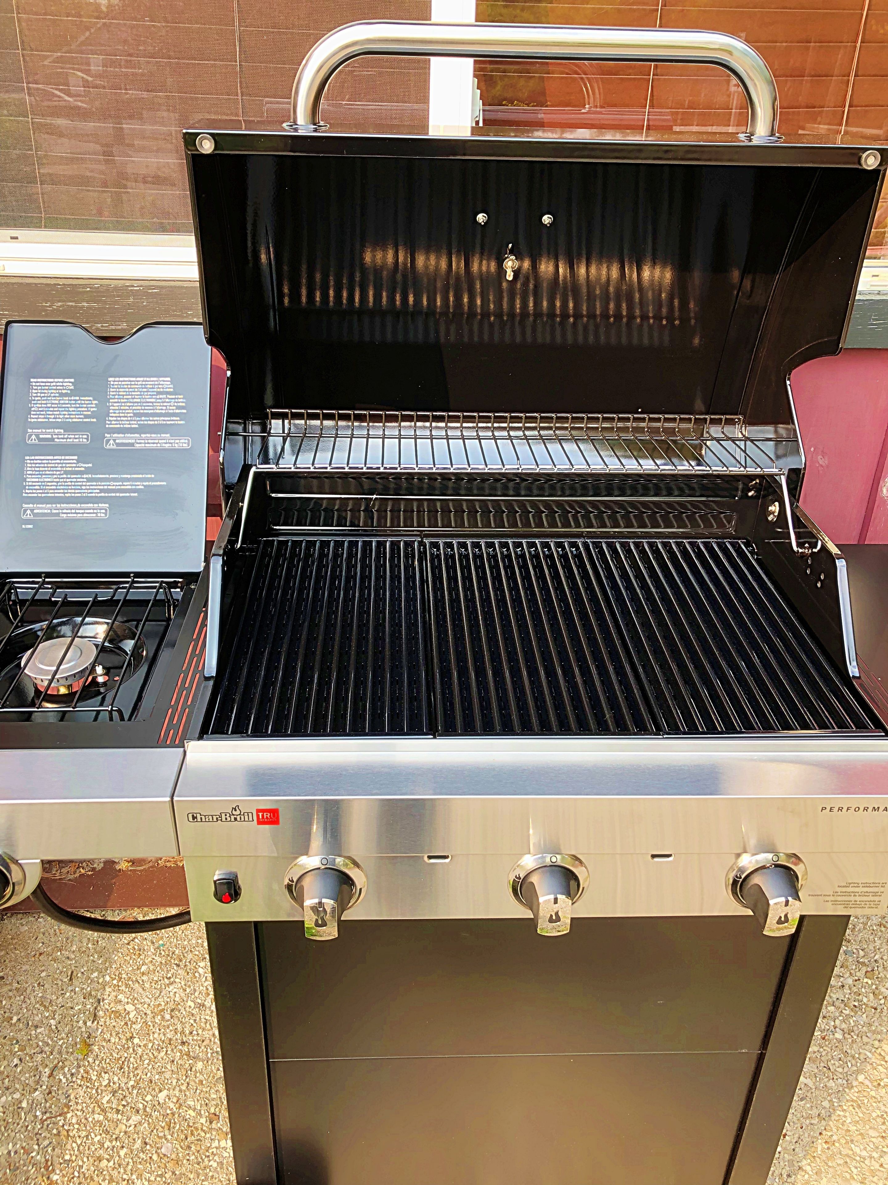 En Char-Broil-grill med en yta i rostfritt stål, en kontrollpanel och ett rött säte.