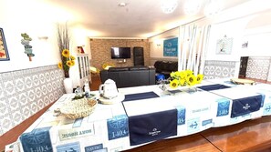 A conference room with a long table, chairs, a television, and a sign indicating 'Dr. Beach House'.
