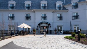 A building with a central entrance, multiple windows, and outdoor seating.