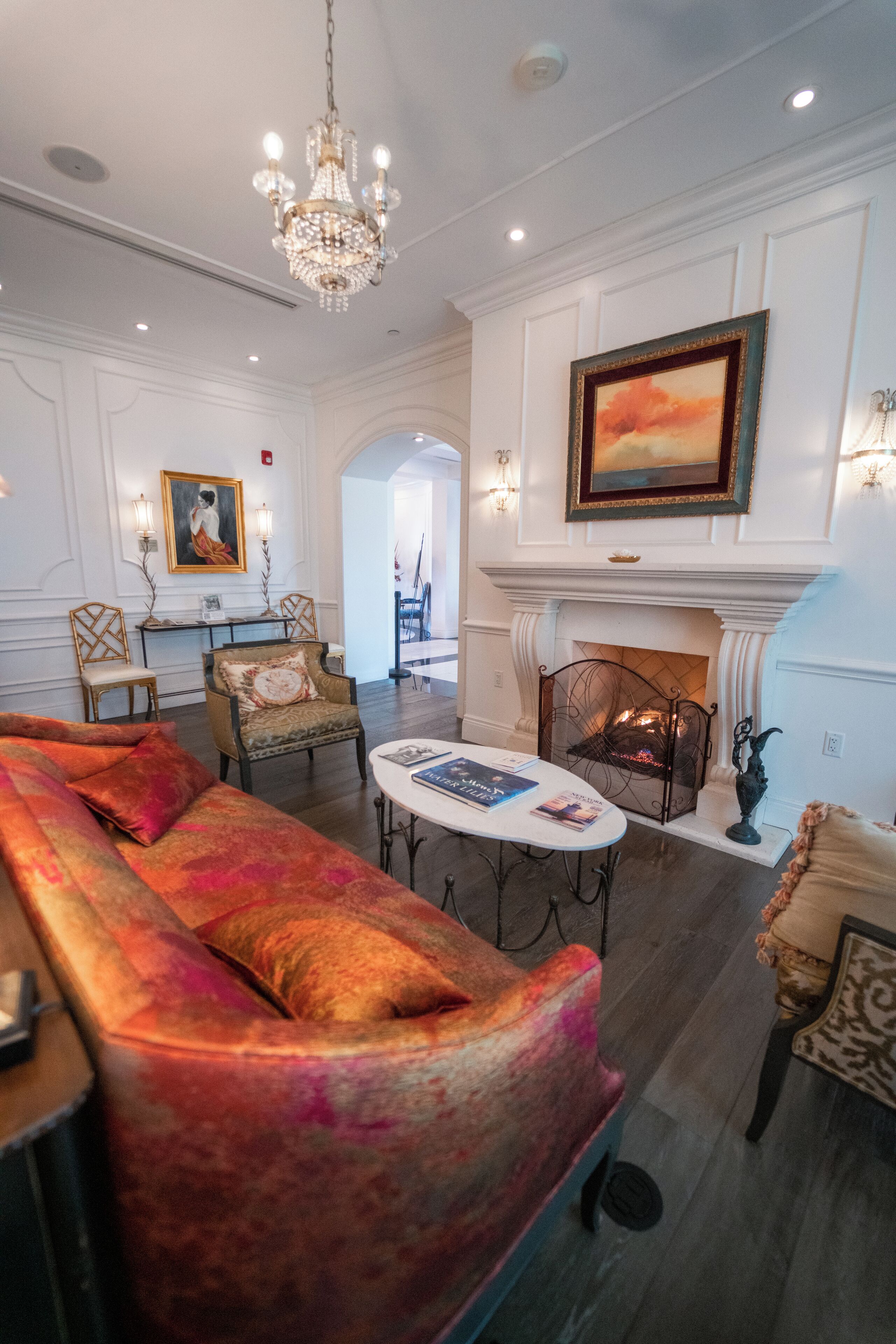 A spacious living room with a large sofa, a fireplace, and elegant wall-mounted lighting.