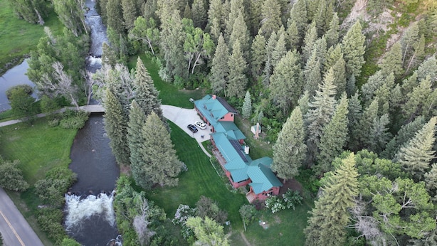 An aerial view of a house surrounded by dense forest, with a river running alongside. - Riverfront (600 feet), 3.65 Acres, Park Like Setting - 2 Bedroom (Durango)