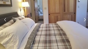 A hotel room with two beds, a wooden door, and a lamp on the left. - Riverfront (600 feet), 3.65 Acres, Park Like Setting - 2 Bedroom (Durango)