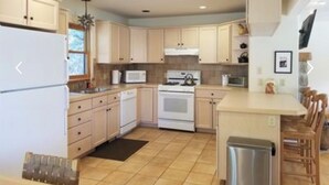 A kitchen with light-colored cabinets, a central island, a stove, and a microwave. - Riverfront (600 feet), 3.65 Acres, Park Like Setting - 2 Bedroom (Durango)